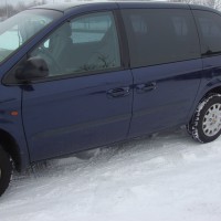 Blauwe Chrysler Voyager met geblindeerde ramen