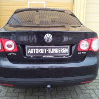 Zwarte Volkswagen Jetta met geblindeerde ruiten